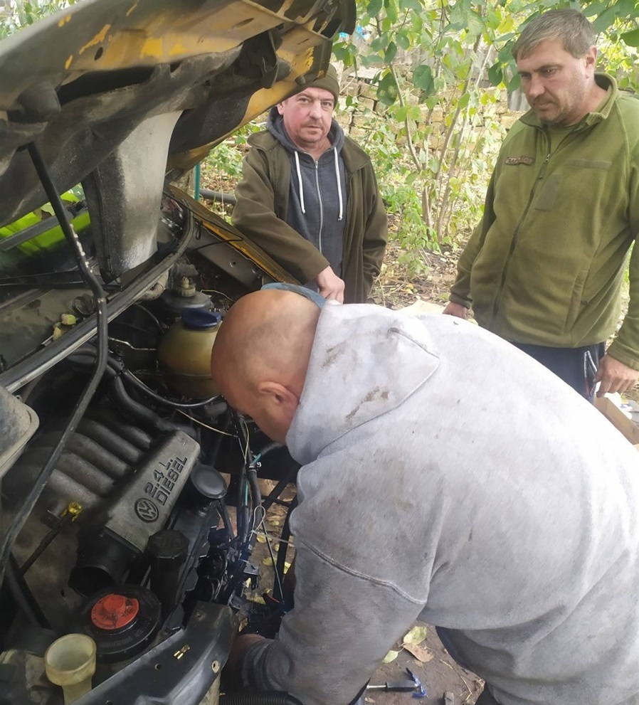 Олег Сабадах ремонтує автомобіль військовим на фронті. 
