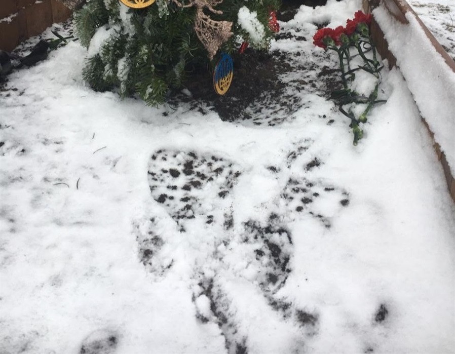Фото, на якому видно сліди від взуття на могилі Героя. 