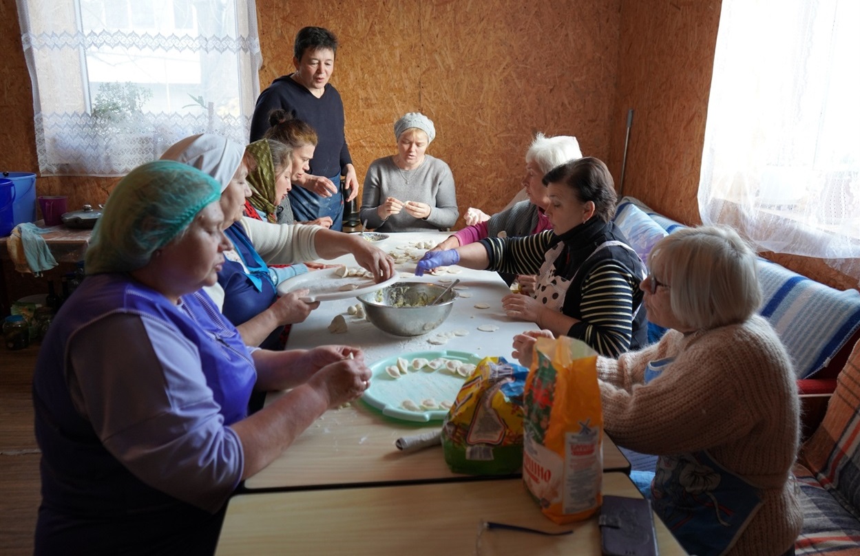 Пані Валентина з подружками ліпить вареники для воїнів.